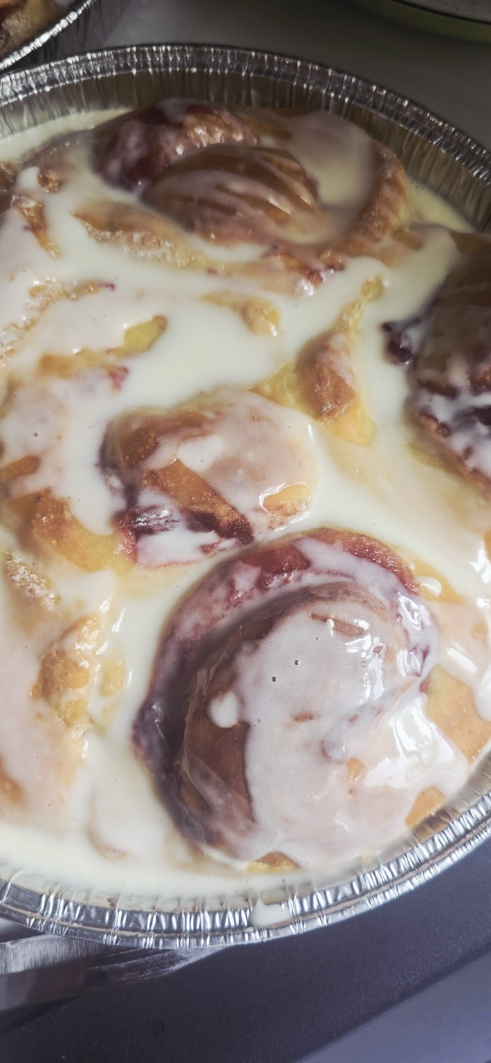 Pan of cranberry orange rolls drizzled with tangy orange glaze